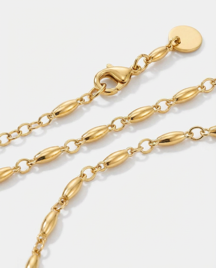 Macro detail of the gold oval link chain necklace, showing shine, texture, and craftsmanship.