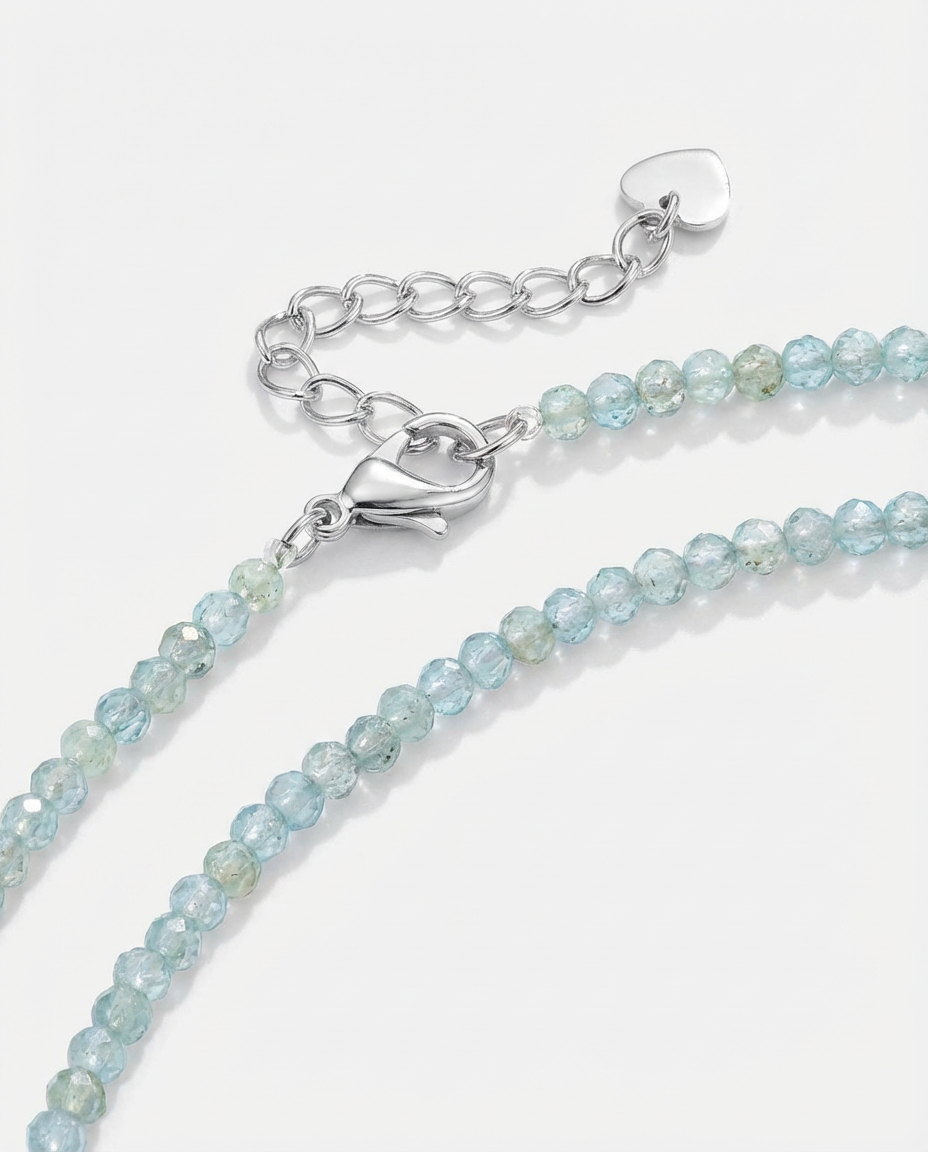 Macro detail of the light blue beaded necklace, showing the small faceted beads and subtle sparkle.
