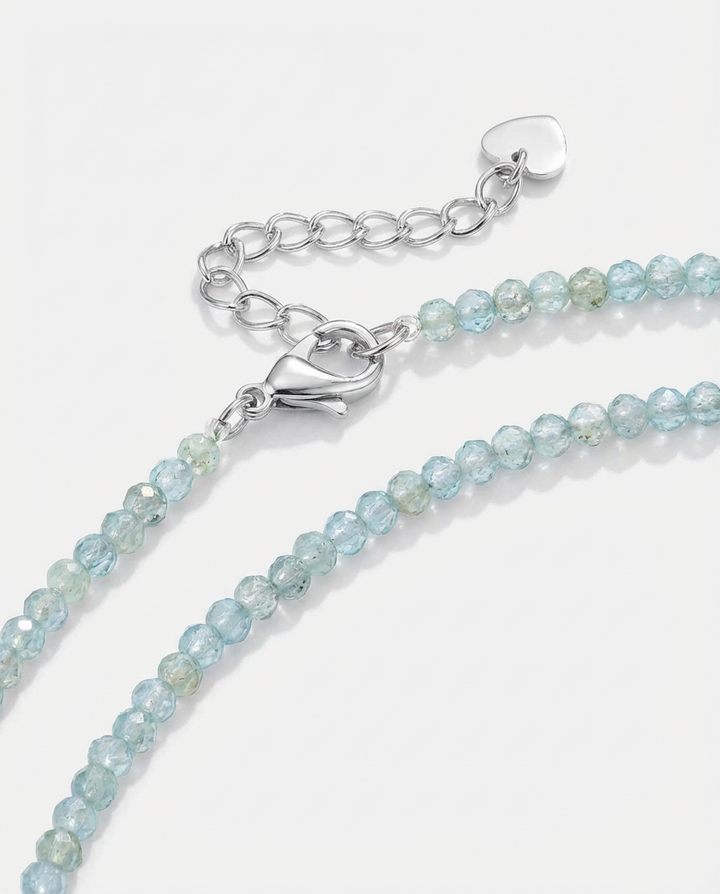 Macro detail of the light blue beaded necklace, showing the small faceted beads and subtle sparkle.