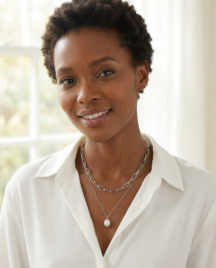 The silver chain and pearl pendant necklace photographed in natural light, showcasing the soft shine of the silver and pearl.